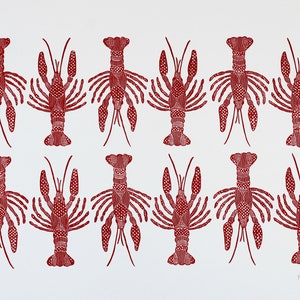 This is an original hand carved block print of a red crawfish or lobster pattern in two rows on fine art paper.
