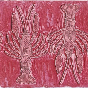 This is the hand carved block that was used to print or stamp the crawfish/lobster pattern on paper and textiles. The block is red ink stained from previous use.
