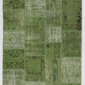 May include: A green patchwork rug with a variety of patterns and designs. The rug is made from recycled materials and has a vintage look.