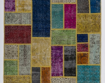 Puede incluir: Una alfombra de patchwork colorida con una variedad de colores y patrones, incluyendo rojo, azul, verde, amarillo y morado. La alfombra está hecha de materiales reciclados y tiene un diseño único tejido a mano.