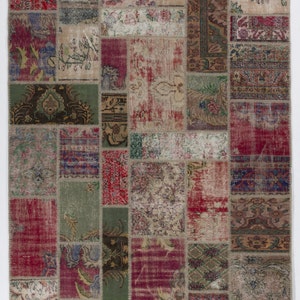 Könnte beinhalten: Ein Patchwork-Teppich mit einem Used-Look im Vintage-Stil. Der Teppich besteht aus zahlreichen rechteckigen Flicken in Rot-, Grün-, Beige- und Lilatönen. Jeder Flicken hat ein einzigartiges Muster, das ein strukturiertes und farbenfrohes Design erzeugt. Geeignet für die Inneneinrichtung.