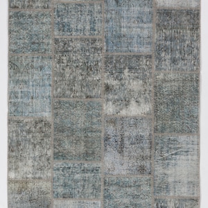 May include: A patchwork rug with a blue and gray color scheme. The rug is made of different pieces of fabric sewn together to create a unique design.