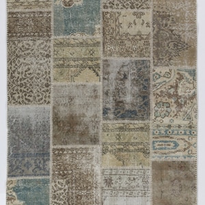 May include: A patchwork rug with a variety of colors and patterns, including beige, brown, and blue. The rug is made of different pieces of fabric that have been sewn together.