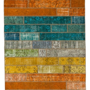 Pode incluir: Um tapete de patchwork colorido com uma variedade de cores e padrões. O tapete é feito de diferentes pedaços de tecido que foram costurados juntos. O tapete tem uma forma retangular e mede aproximadamente 90 cm por 150 cm.