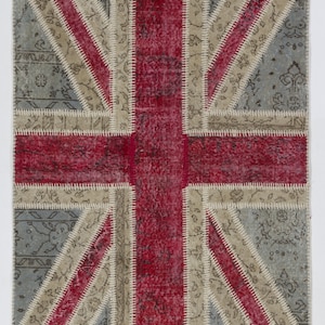 May include: A patchwork rug with the design of the Union Jack flag. The rug is made of different fabrics in shades of red, white, and blue.