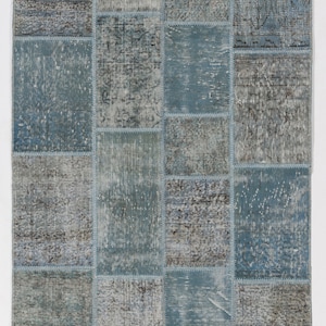 Faded Blue and Grey Patchwork Rug. Soft Pastel coloured patches of overdyed rugs stitched together to make a contemporary rug