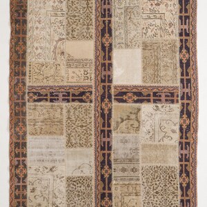 May include: A patchwork rug with a beige background and a dark brown border. The rug is made up of different pieces of fabric, each with a unique pattern. The border is decorated with a geometric design.