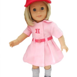 May include: A pink and red baseball uniform for a doll, featuring a red cap with a white "H" on the front, a pink dress with a white "H" on the chest, a red belt, and gray socks with black sneakers.