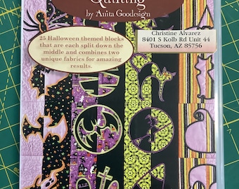 May include: A DVD case with a Halloween theme. The case features a colorful patchwork design with various Halloween motifs, including bats, ghosts, and skulls. The title of the DVD is "Halloween Mirror Blocks" and the text "Mix & Match Quilting by Anita Goodesign" is also visible. The case includes the name and address of the creator, Christine Alvarez.