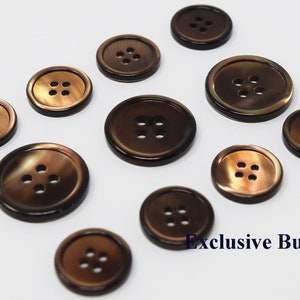 以下が含まれることがあります： 4つの穴のある茶色のボタンが10個セットです。ボタンは光沢のある虹色の素材で作られています。ボタンは白い背景に円形に配置されています。画像の右下隅に「Exclusive Buttons」というテキストが表示されています。
