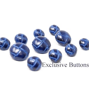 Puede incluir: Una colección de diez botones de cuero azul con un patrón tejido. Los botones están dispuestos en un semicírculo sobre un fondo blanco. Botones Exclusivos.