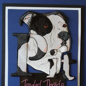 Può includere: Toppa ricamata di un Pitbull bianco e nero con la parola "Pit" in lettere bianche. La toppa è realizzata da Tangled Threads Embroidery.