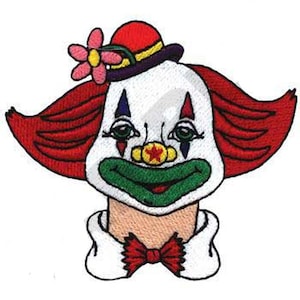 Puede incluir: Cara de payaso bordada con pelo rojo, sombrero rojo y flor. El payaso tiene una cara blanca con detalles rojos, azules y verdes, una boca verde y una pajarita roja. La cara del payaso está centrada.