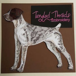 May include: Embroidered patch of a German Shorthaired Pointer dog, standing on a brown background. The patch is made by Tangled Threads Embroidery.