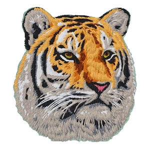 May include: An embroidered patch featuring the head of a tiger. The design showcases orange, black, and white thread detailing, with green eyes and a pink nose. The embroidery is dense, capturing the texture of fur and the tiger's facial features.