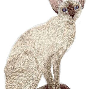 May include: An embroidered patch featuring a Siamese cat in a seated position. The cat has a cream-colored body, dark brown points on the ears, face, and tail, and bright blue eyes. The embroidery shows detailed stitching throughout the design.
