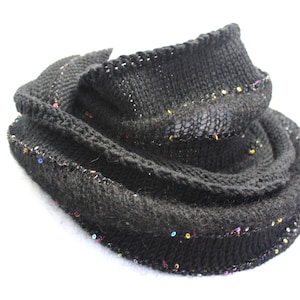 May include: Black knitted scarf with colorful sequins around the edges.