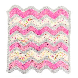 May include: A knitted baby blanket with a wavy pattern in pink, white, and gray.