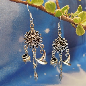 May include: Silver dangle earrings with a circular charm, a witch's hat, a cauldron, and a wand charm.