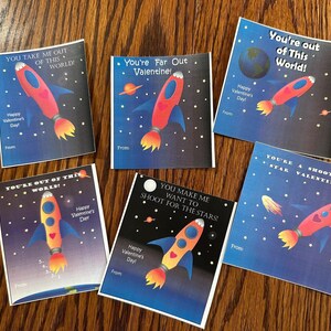 Puede incluir: Seis tarjetas de San Valent&iacute;n coloridas con cohetes y dise&ntilde;os con tem&aacute;tica espacial. Las tarjetas tienen mensajes como "You're Far Out Valentine!" y "You Make Me Want To Shoot For The Stars!"