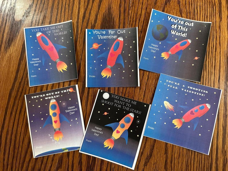 Puede incluir: Seis tarjetas de San Valent&iacute;n coloridas con cohetes y dise&ntilde;os con tem&aacute;tica espacial. Las tarjetas tienen mensajes como "You're Far Out Valentine!" y "You Make Me Want To Shoot For The Stars!"