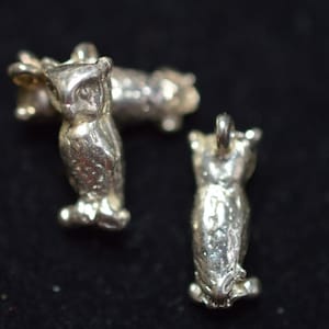 May include: Three silver owl charms, each with a detailed design and a loop for attaching to a necklace or bracelet.