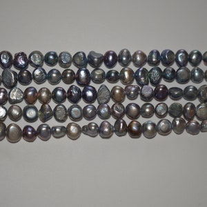 Pode incluir: Um fio de pérolas de água doce cinzas iridescentes. As pérolas são de forma irregular e têm um aspeto ligeiramente barroco.