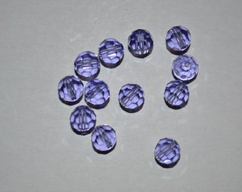 May include: A group of 12 purple glass beads with a faceted design. The beads are arranged in a semi-circle shape.