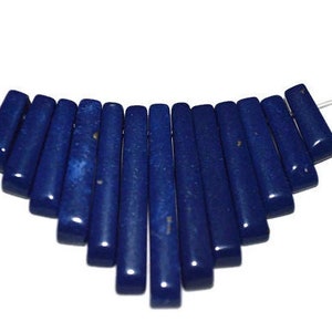 Puede incluir: Una hebra de cuentas de lapislázuli azul oscuro, cada cuenta es un prisma rectangular, las cuentas están enhebradas en un alambre de plata con cierres de plata en cada extremo.