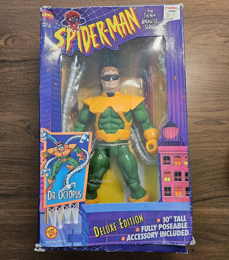 以下が含まれることがあります： デラックス版スパイダーマンのアクションフィギュア、ドクター・オクトパス付き。フィギュアの高さは25.4cmで、完全にポーズ可能で、アクセサリーが付属しています。パッケージには、「スパイダーマン」と「ドクター・オクトパス」の文字が入った紫と青の都市景観デザインが施されています。