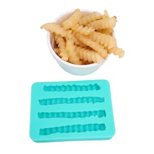May include: A bowl of crinkle-cut chips sits above a turquoise silicone mould. The chips are golden brown and appear crispy. The mould has four rectangular cavities, each with a crinkle-cut pattern, designed for shaping food.