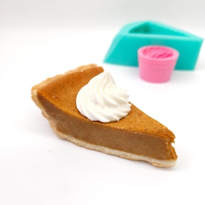 May include: A slice of pumpkin pie topped with a swirl of whipped cream.