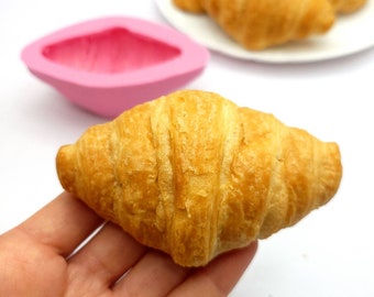 May include: A golden brown croissant, freshly baked and ready to eat.