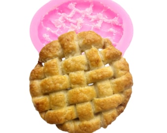 May include: A pink silicone mold for baking a pie crust with a lattice top. The mold is shown with a baked pie crust inside.