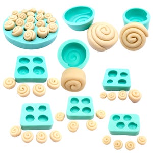 May include: A set of silicone molds for making miniature cinnamon rolls. The molds are turquoise blue and come in different sizes. There are also several miniature cinnamon rolls made with fondant or modeling clay.