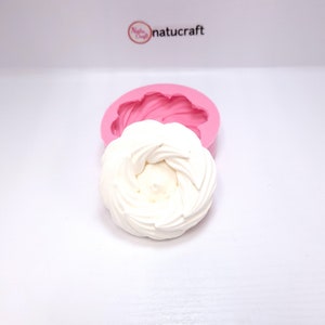 Op de afbeelding: Een wit, spiraalvormig decoratief item naast een roze siliconen mal. De mal heeft de vorm van een bloem. Het logo "Natucraft" staat in de rechterbovenhoek.