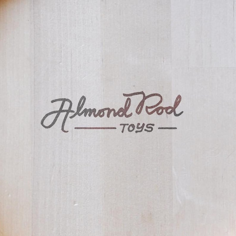 May include: A white wooden box with the text "Almond Pool Toys" in black and brown lettering.