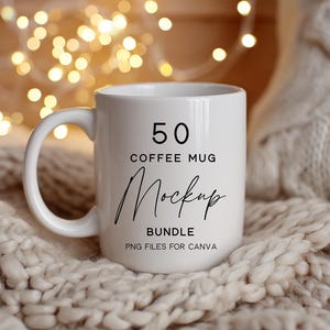 May include: A white coffee mug with a large handle, featuring the text "50 COFFEE MUG Mockup BUNDLE PNG FILES FOR CANVA". The mug is set against a soft, textured background with warm, glowing lights.