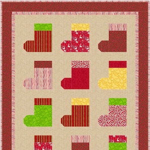 May include: A Christmas-themed quilt featuring nine colorful stockings. The stockings have various patterns, including stripes, polka dots, and festive designs. The quilt has a tan background and a red border with a striped pattern.