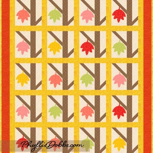 Könnte beinhalten: Ein Quiltmuster mit braunem, gelbem und weißem Hintergrund. Das Muster zeigt ein sich wiederholendes Design aus braunen Baumstämmen mit grünen, gelben, rosa und roten Blättern. Der Text "Phyllis Dobbs.com" befindet sich am unteren Rand des Quilts.