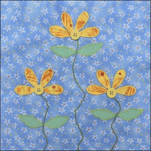 May include: Three yellow fabric flowers with brown centers and green leaves on a blue background with white flowers.