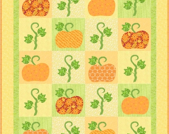 Peut inclure: Un bloc de courtepointe avec un motif de patchwork représentant des citrouilles orange aux motifs différents et des vignes vertes. Le fond est jaune clair avec une bordure verte.