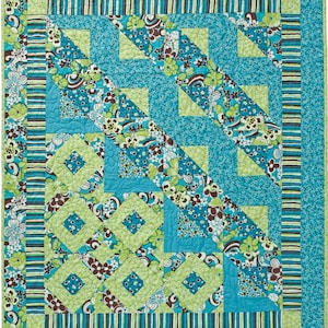 May include: A quilt with a geometric pattern in shades of blue, green, and brown. The quilt is made up of squares, triangles, and diamonds. The fabric has a floral print.