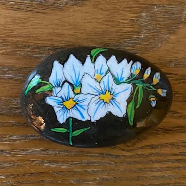 Painted White Freesia Floral stone with black acrylic background  and glossed, to be used as a paperweight or garden stone.