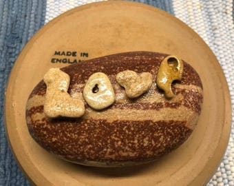 Lake Superior Stone with tiny letter stones spelling out LOVE glued to it and glossed on whole thing for paperweight or garden stone.