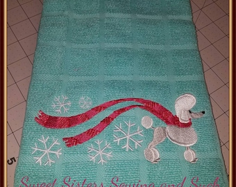 May include: A teal kitchen towel with a white embroidered poodle wearing a red scarf and snowflakes. The text "Sweet Sisters Sewing and Such" is embroidered at the bottom.