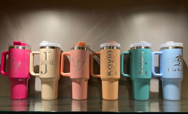 Row of colorful engraved tumblers — assorted examples showcasing name and design variations in multiple colors.