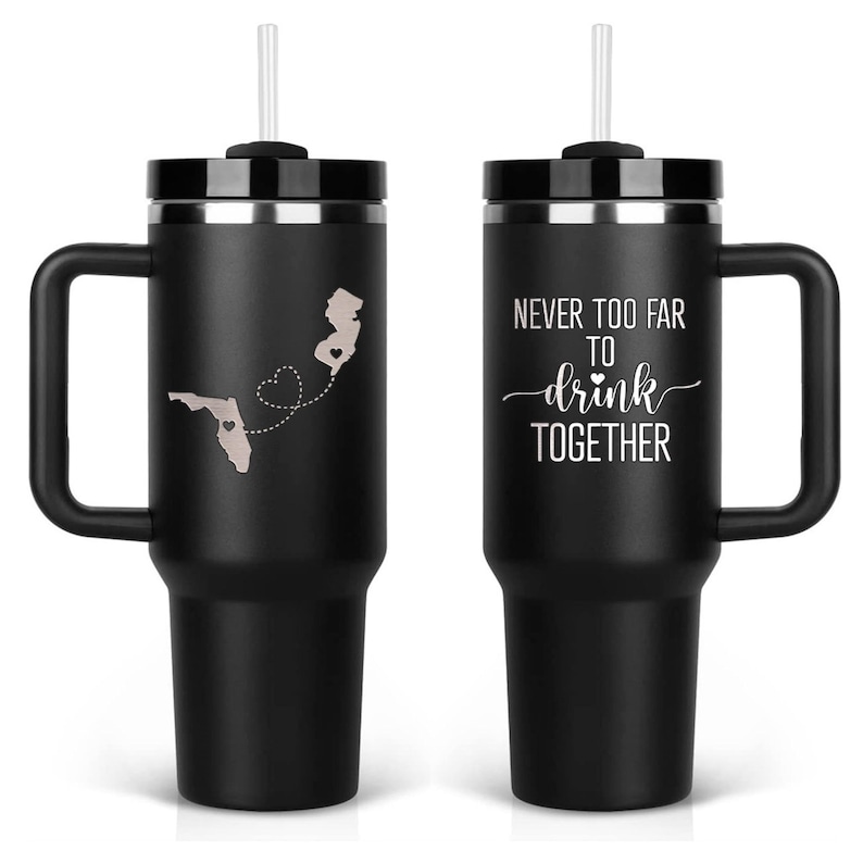 Pair of black engraved tumblers — front and back engraving shown with travel quote “Never too far to drink together.” Two sides engraving