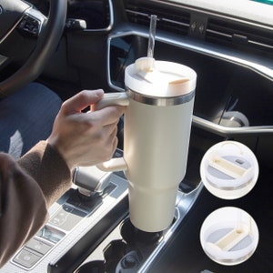 Tumbler in car cup holder — stainless steel insulated mug with handle and straw, ideal for daily travel or work use.
