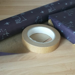 May include: A roll of brown paper with a white deer pattern, a roll of dark blue paper with a white deer pattern, and a roll of brown tape.